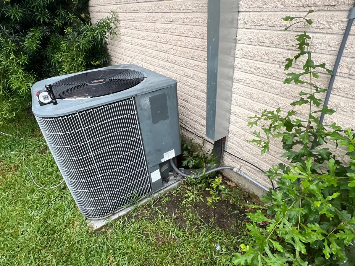 New air conditioner condenser installed beside a home